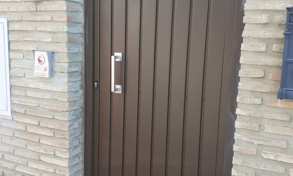 Puerta de entrada a vivienda en Sevilla - duelas de acero con arco superior rebajado lacada RAL 8014 Texturizado - Rollmatic